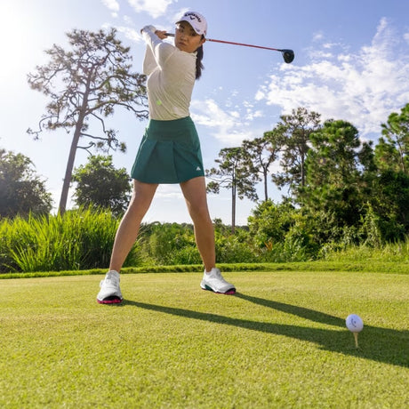 Woman playing golf in Adidas golf apparel